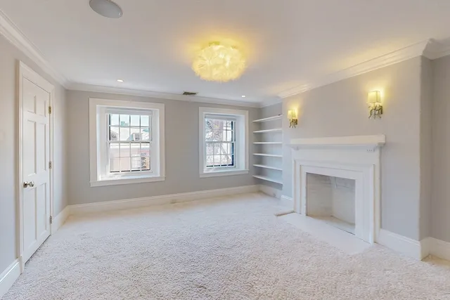 a view of an empty room with a fireplace and a window