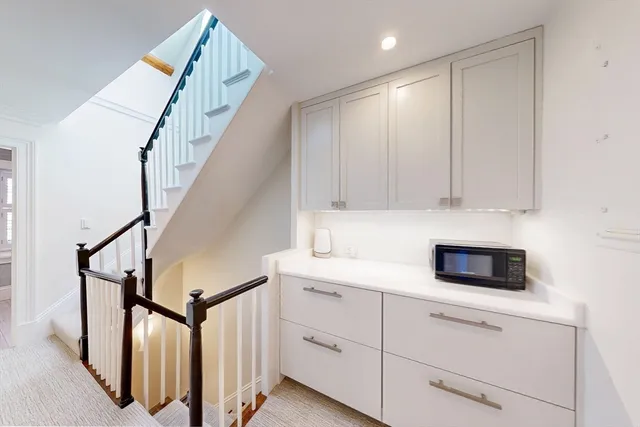 a kitchen with white cabinets and white appliances