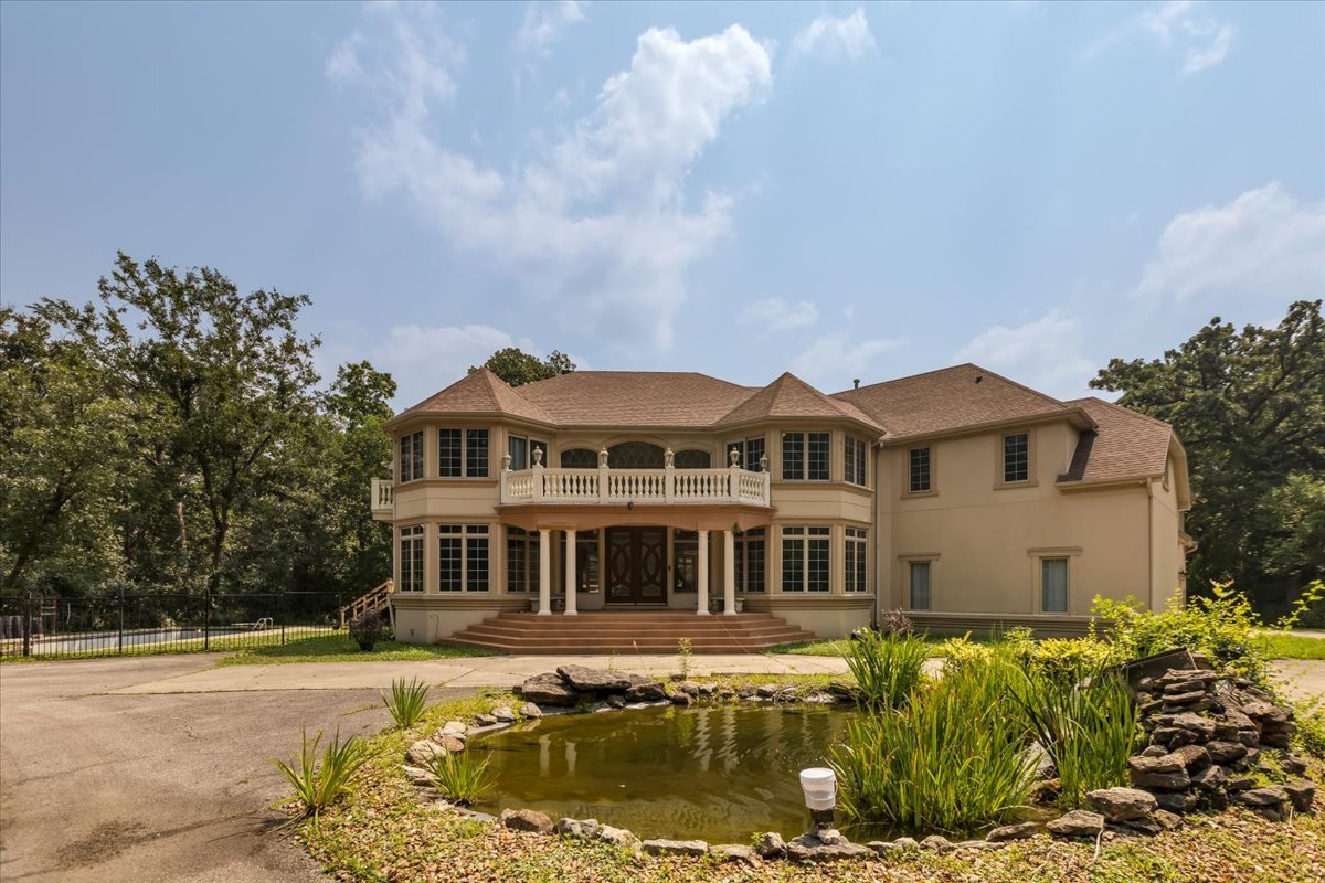 a front view of a house with a garden and trees
