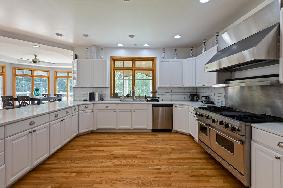 872 Rosedale Terrace Crete, IL 60417 - Photo 21 of 54 a large kitchen with stainless steel appliances granite countertop a stove a sink dishwasher and white cabinets with wooden floor