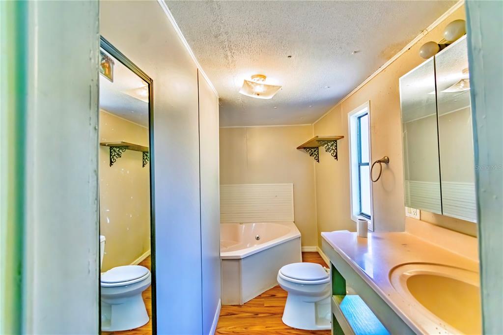 2958 Northeast 161 Place Citra, FL 32113 - Photo 14 of 26 a bathroom with a granite countertop toilet sink and mirror