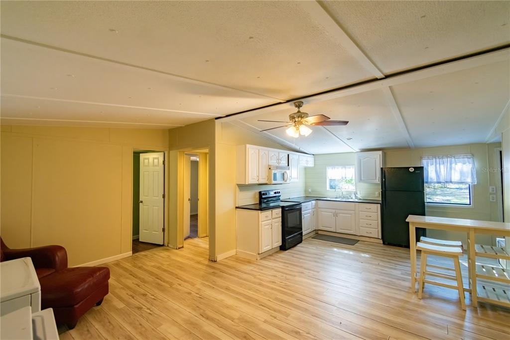 2958 Northeast 161 Place Citra, FL 32113 - Photo 7 of 26 a view of a kitchen with a refrigerator and wooden floor