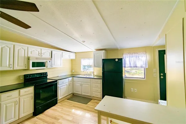 a kitchen with a sink a refrigerator and cabinets