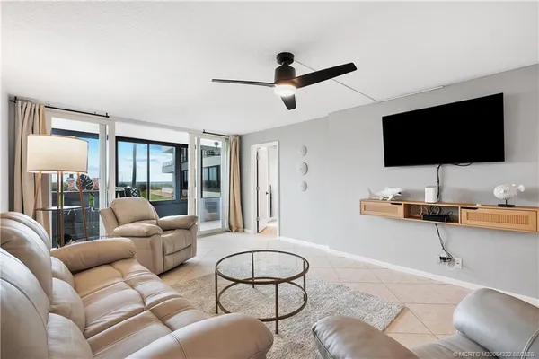 a living room with furniture a flat screen tv and a window