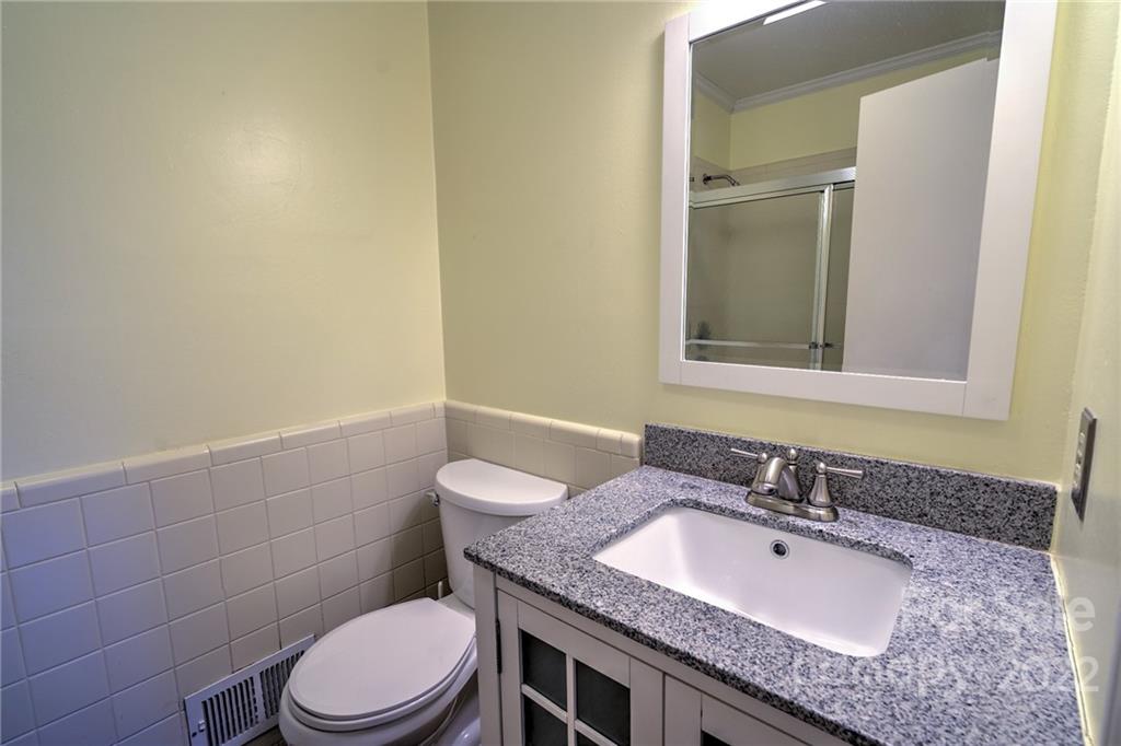 311 Curtis Drive Rockingham, NC 28379 - Photo 20 of 40 a bathroom with a granite countertop sink a toilet and a mirror