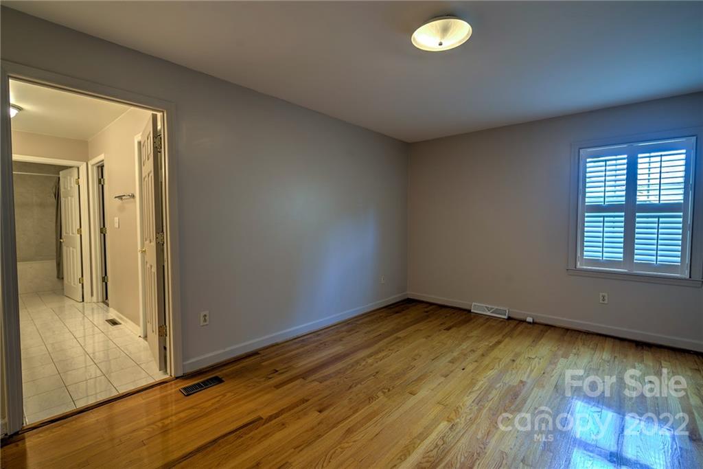 311 Curtis Drive Rockingham, NC 28379 - Photo 23 of 40 an empty room with wooden floor and windows
