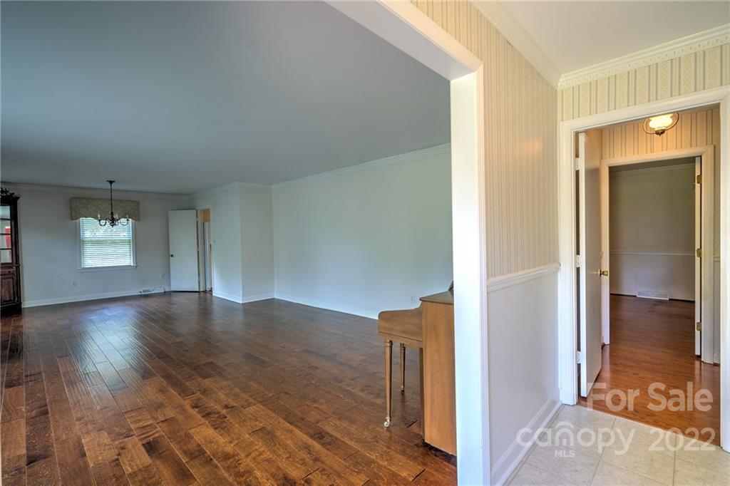 311 Curtis Drive Rockingham, NC 28379 - Photo 5 of 40 a view of a hallway with wooden floor and a living room