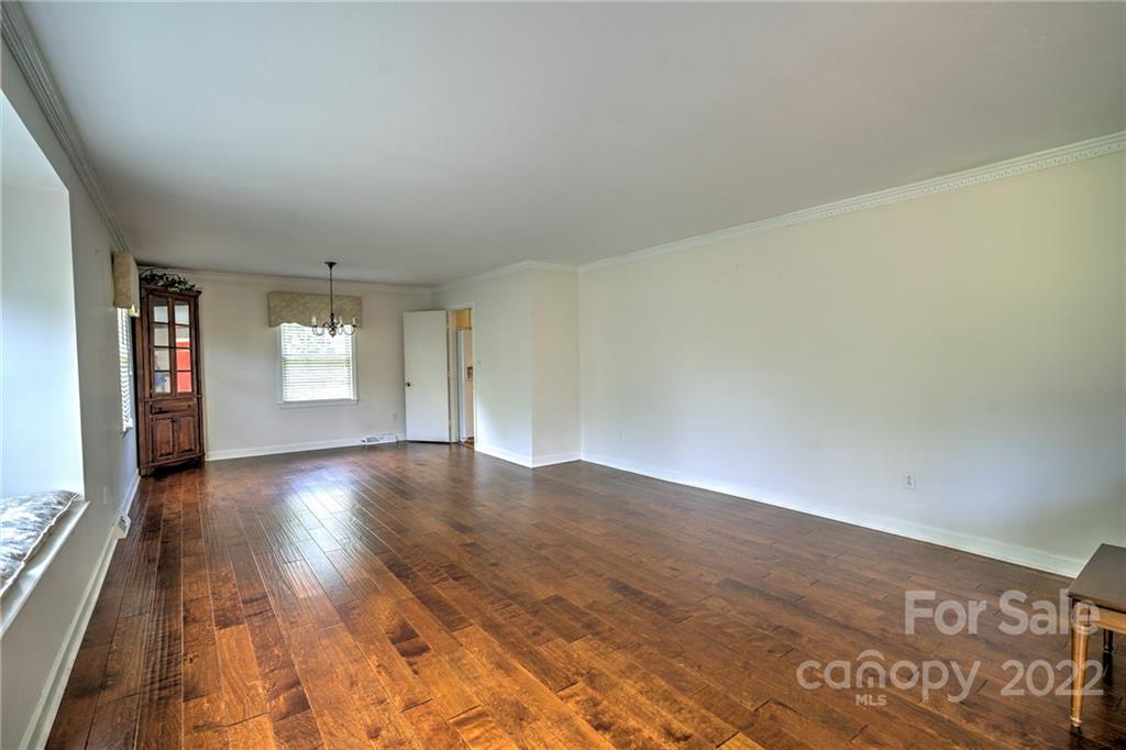 311 Curtis Drive Rockingham, NC 28379 - Photo 9 of 40 an empty room with wooden floor and windows