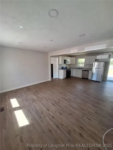 a view of empty room with wooden floor