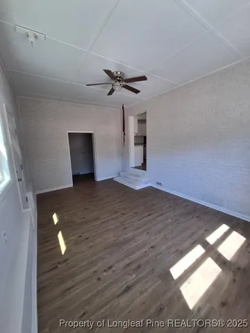 a view of empty room with wooden floor