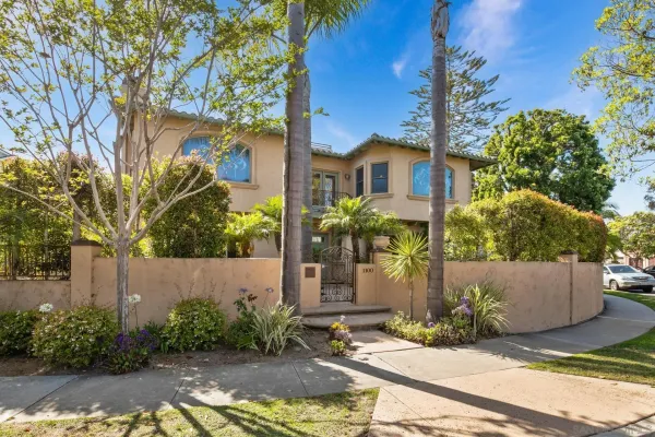 a front view of a house with a yard and tree s