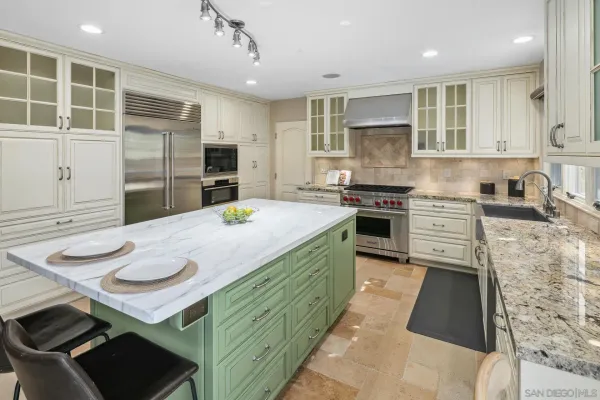 a kitchen with kitchen island stainless steel appliances a sink stove and refrigerator