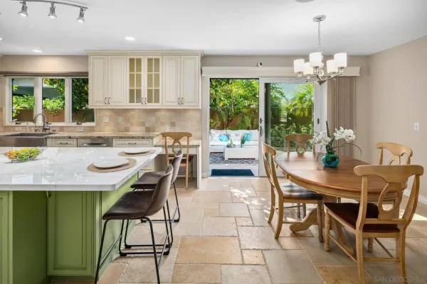 a dining room filled chandelier and kitchen view