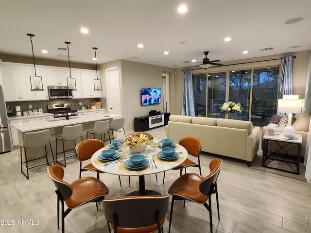 a dining room with stainless steel appliances kitchen island granite countertop a dining table chairs and view kitchen