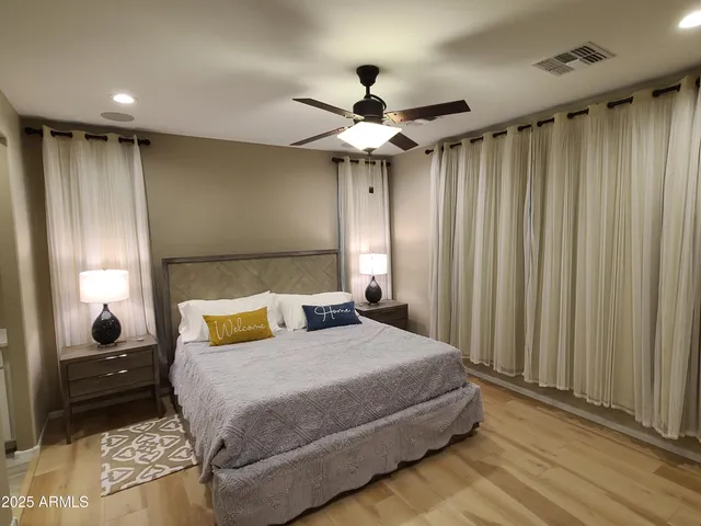 a bedroom with a large bed and a chandelier