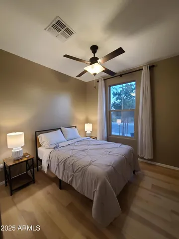 a bedroom with a bed ceiling fan and a window