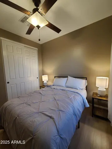 a bedroom with a bed and a ceiling fan