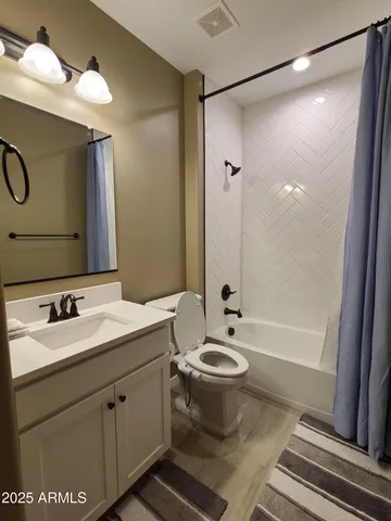 a bathroom with a double vanity sink toilet mirror and bathtub