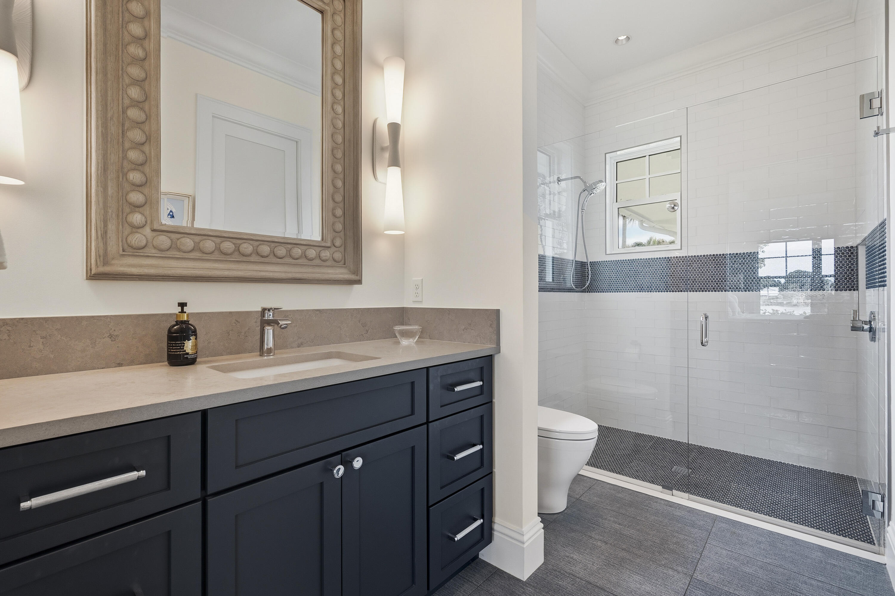3973 Southeast Topsail Court Stuart, FL 34997 - Photo 16 of 38 a bathroom with a granite countertop sink a toilet and a mirror
