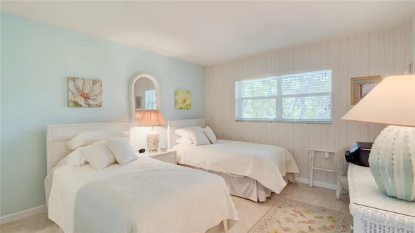 a bedroom with two beds and a window