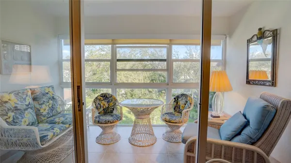 a living room with furniture and a floor to ceiling window
