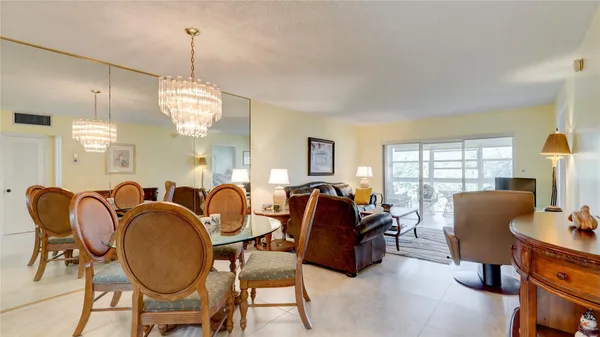 a dining room with furniture a chandelier and window