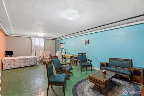 a work room with furniture a rug and a bookshelf