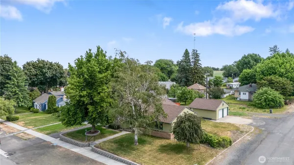 a view of a house with backyard and trees