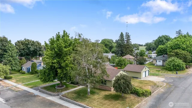 a view of a house with backyard and trees