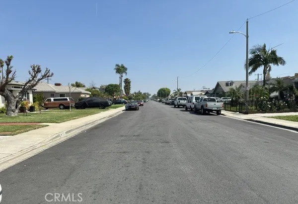 a view of a street with cars parked on the road