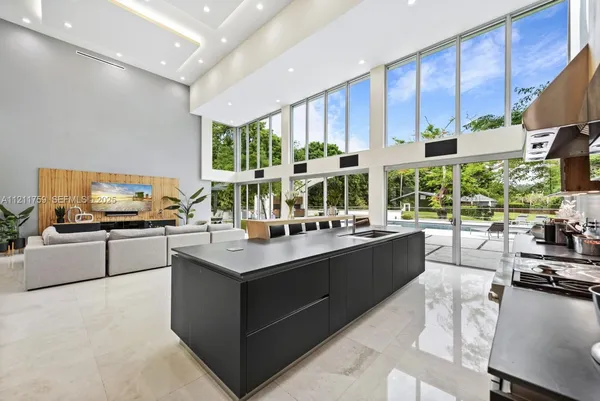 a kitchen with stainless steel appliances granite countertop a stove refrigerator and a dining table with wooden floor
