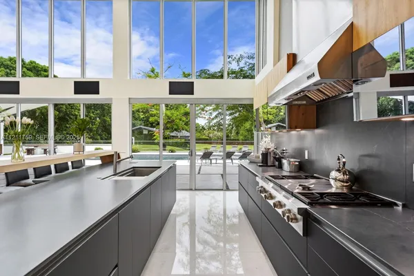 a kitchen with stainless steel appliances kitchen island granite countertop a stove and a sink