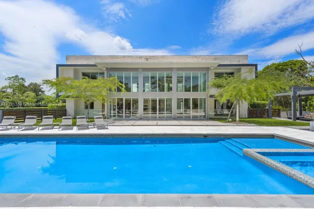 a front view of a house with swimming pool having outdoor seating