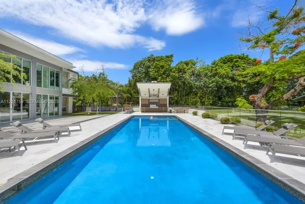 a front view of a house with swimming pool having outdoor seating