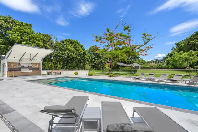 a view of a house with backyard and sitting area