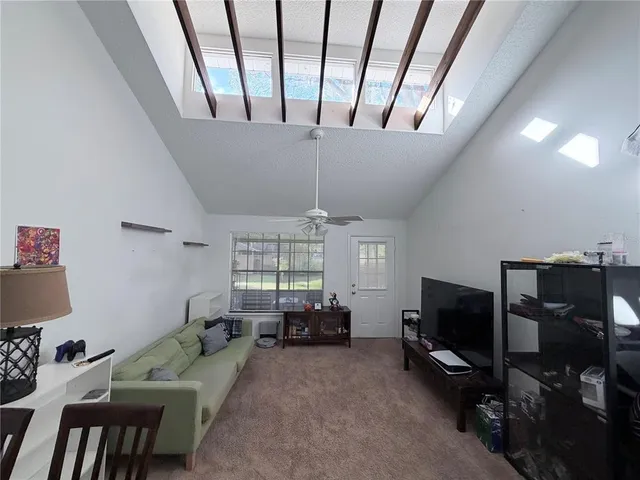 a living room with furniture a flat screen tv and a large window