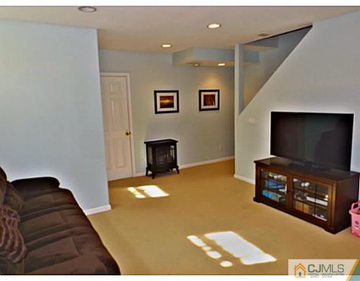 10 Carnation Road Monroe Township, NJ 08831 - Photo 21 of 25 a living room with furniture and a flat screen tv