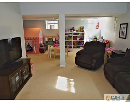 10 Carnation Road Monroe Township, NJ 08831 - Photo 22 of 25 a living room with furniture and a flat screen tv
