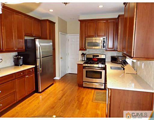 10 Carnation Road Monroe Township, NJ 08831 - Photo 7 of 25 a kitchen with a refrigerator stove and microwave