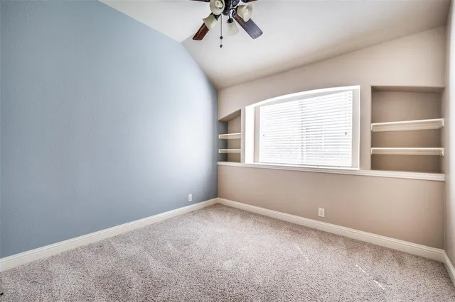an empty room with a window and a ceiling fan