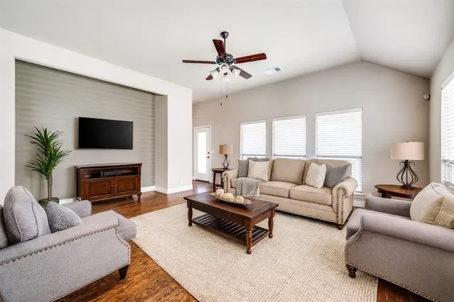 a living room with furniture a fireplace and a flat screen tv
