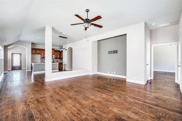 a view of a livingroom with wooden floor and a ceiling fan