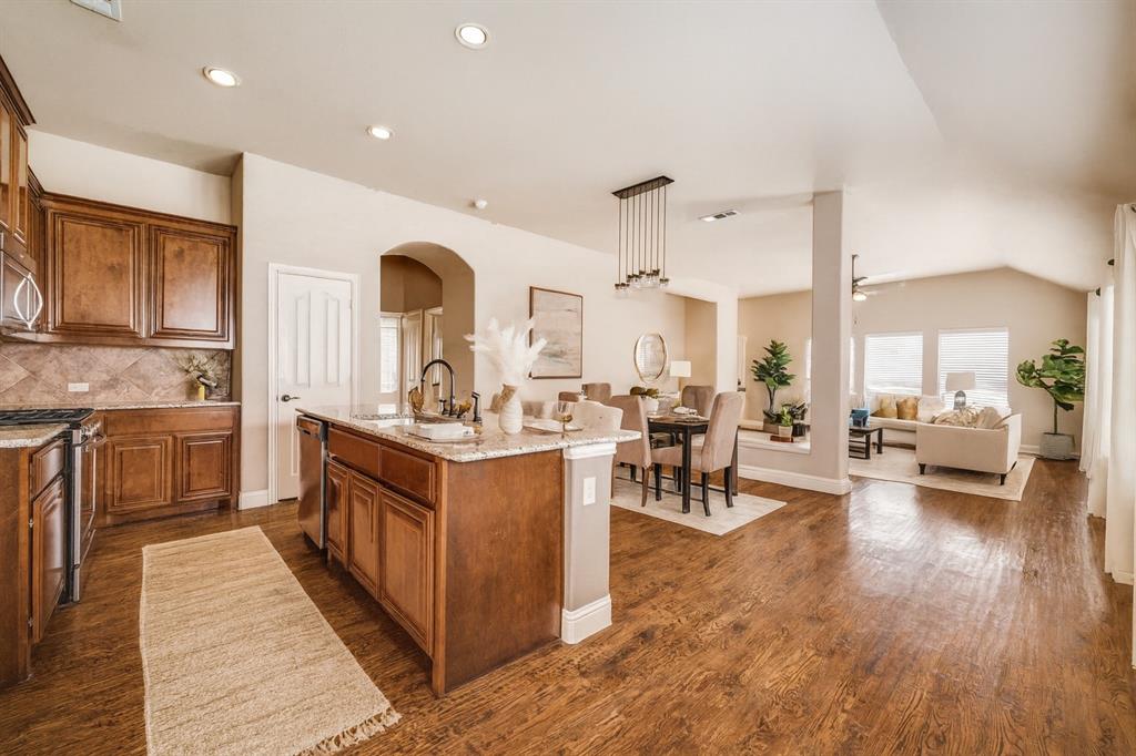 817 Lighthouse Lane Savannah, TX 76227 - Photo 10 of 20 a kitchen with stainless steel appliances granite countertop a lot of counter space and wooden floors