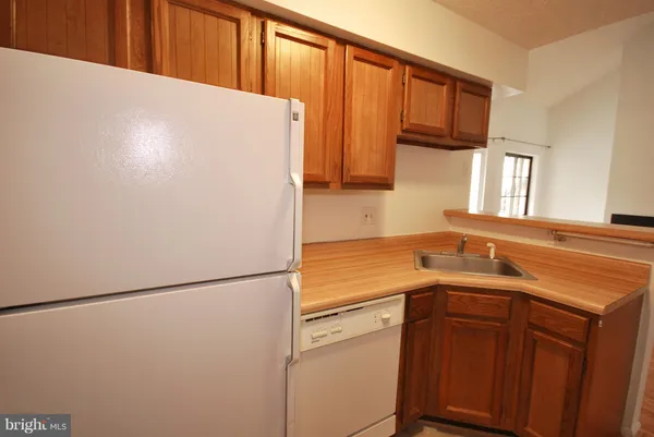a kitchen with a white cabinets and a refrigerator