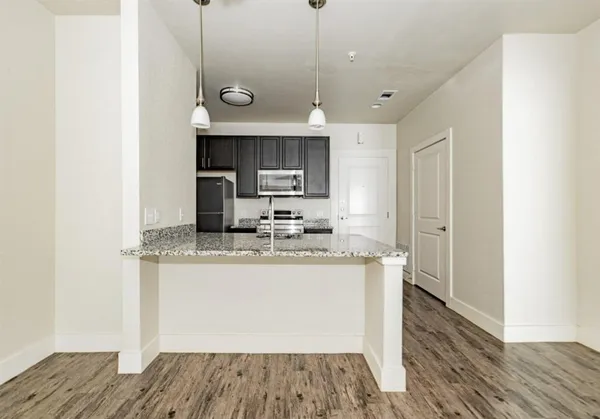 a kitchen with granite countertop a sink and a refrigerator