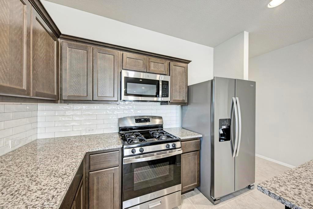 1209 Goforth Road Kyle, TX 78640 - Photo 10 of 32 A well-appointed kitchen showcasing contemporary cabinetry, gleaming granite countertops, and modern stainless steel appliances.
