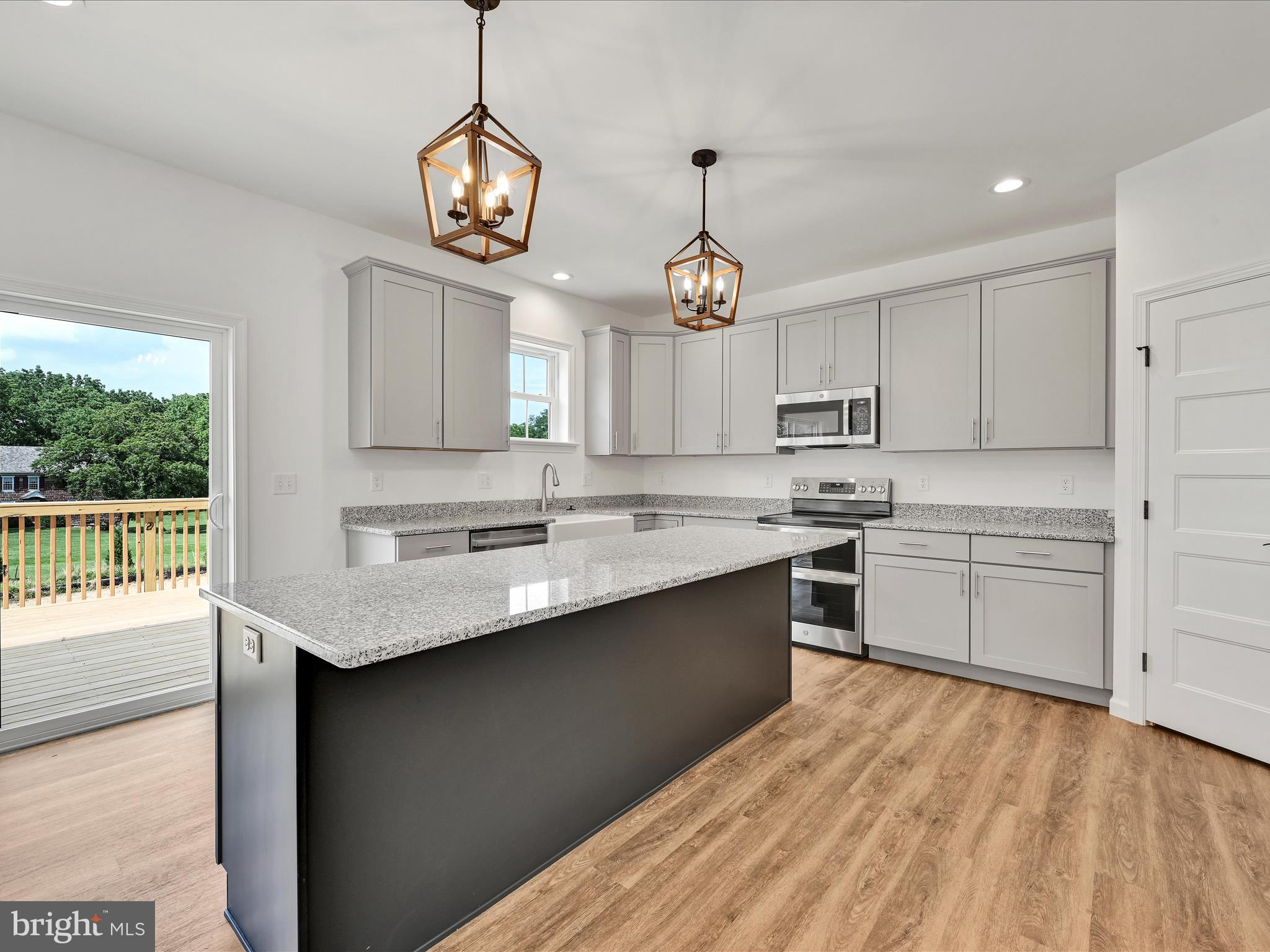 2 Stream Drive Carlisle, PA 17013 - Photo 4 of 6 a kitchen with stainless steel appliances granite countertop a sink dishwasher a stove a dining table and chairs with wooden floor
