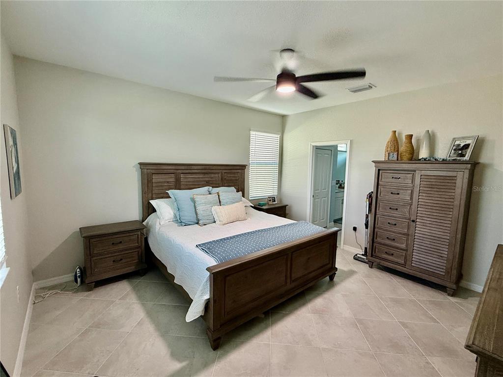 10852 Sun Drop Street Venice, FL 34293 - Photo 8 of 15 a bedroom with a bed and a ceiling fan
