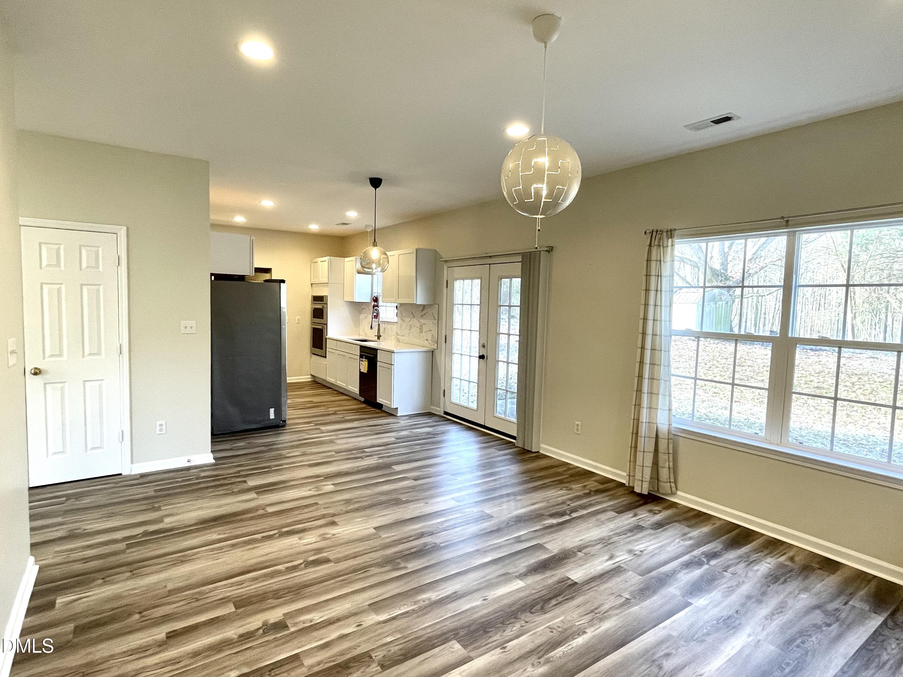 5506 Grand Mesa Drive Durham, NC 27713 - Photo 13 of 28 a view of a kitchen with a refrigerator cabinets and wooden floor