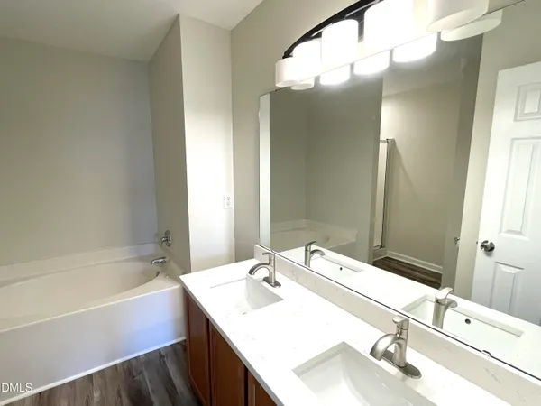 a bathroom with a tub sink and mirror
